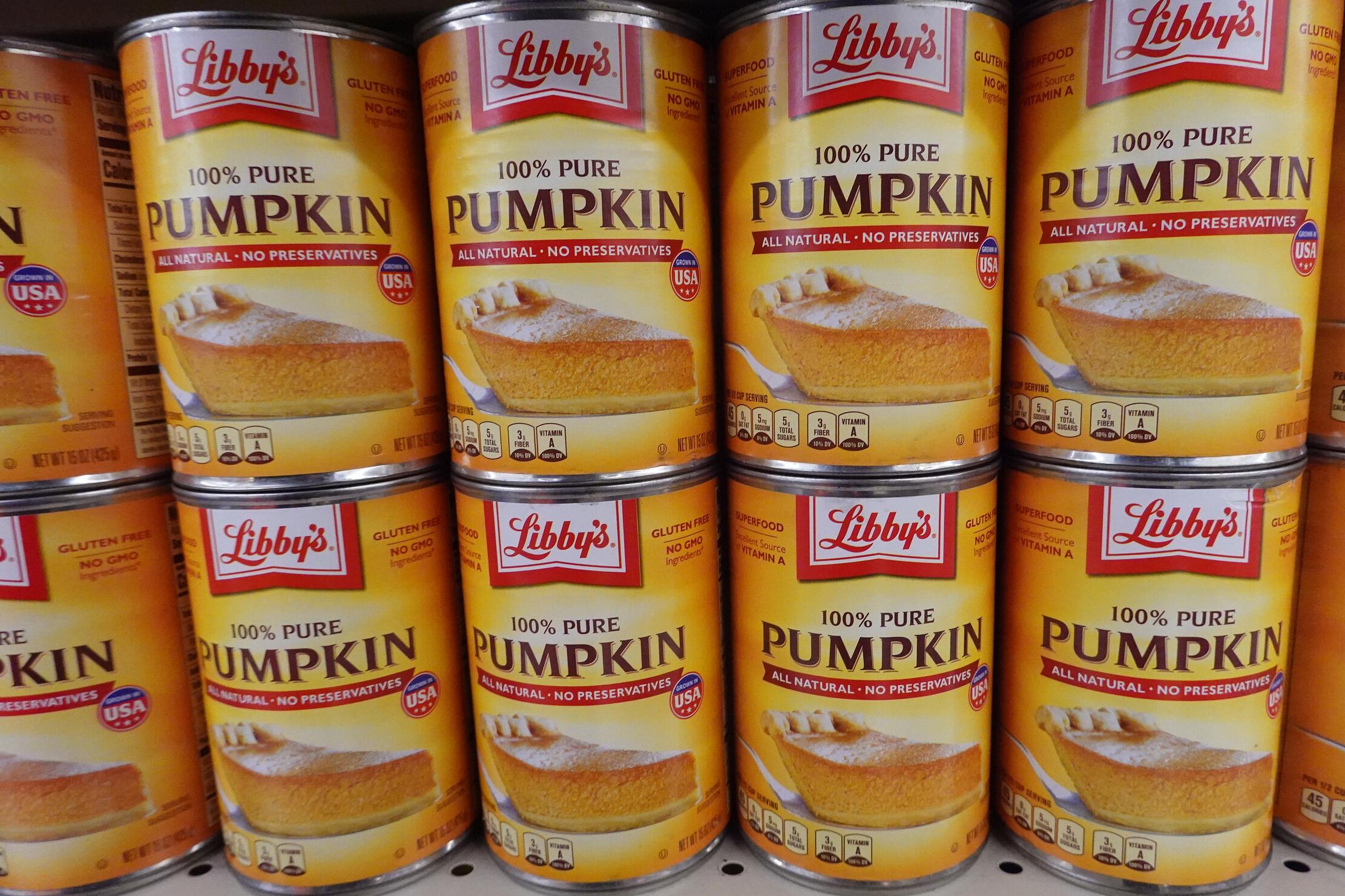 A close-up photo of multiple rows of Libby's canned pumpkin stacked on a store shelf.