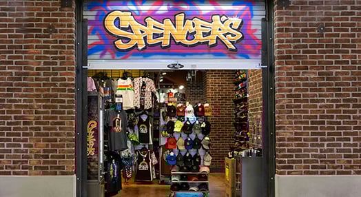 man dancing in front of Spencer's store