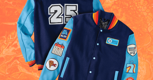 A blue Aldi-branded varsity jacket with the number 25 on it. Patches feature a calendar, Aldi's logo, a spice of pizza, and a shopping cart.