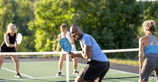 Several people playing pickleball.