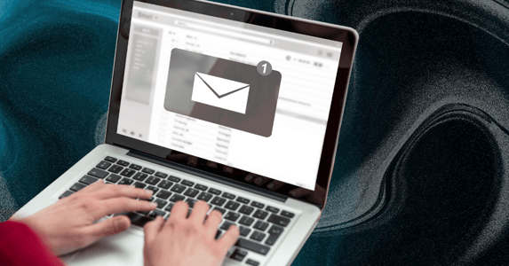 A person on a laptop showing an email inbox icon. 